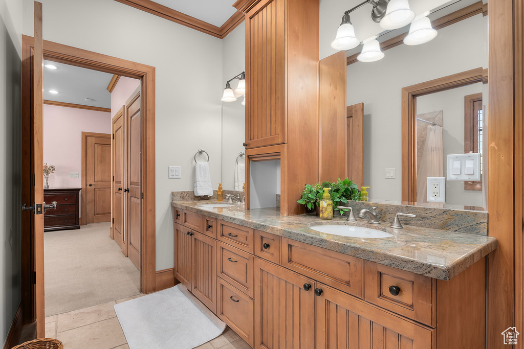 Bathroom with crown molding, vanity, and tile patterned floors