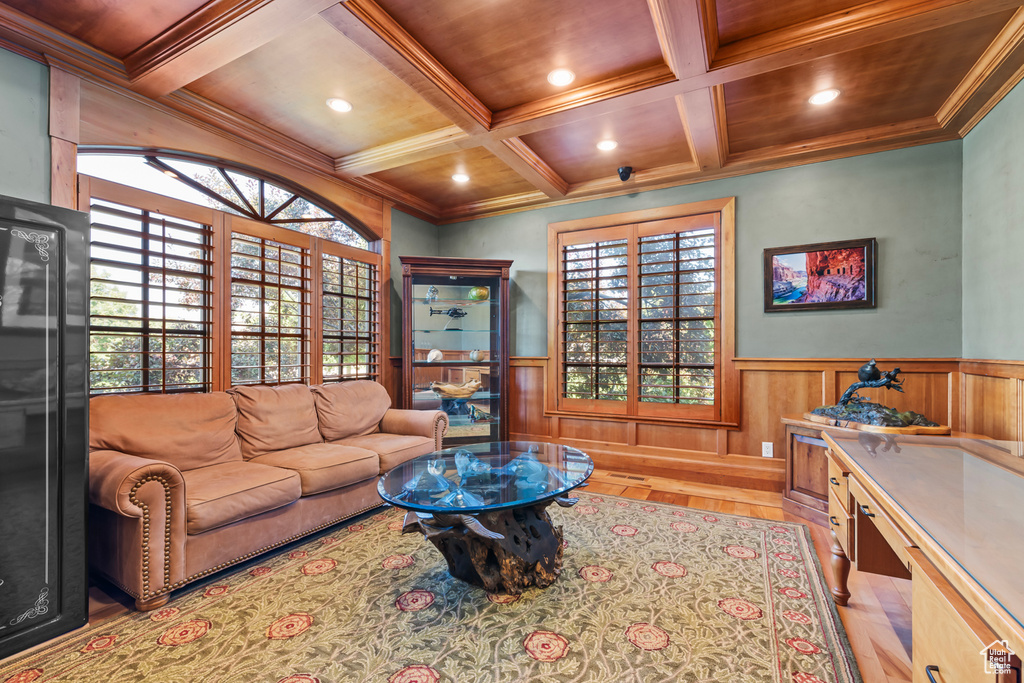 Living area with light wood-type flooring, coffered ceiling, beamed ceiling, and ornamental molding