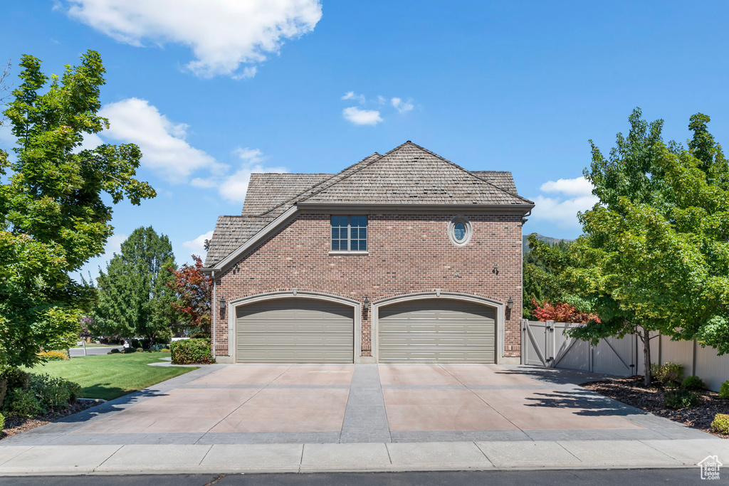 View of side of home with a garage and a lawn