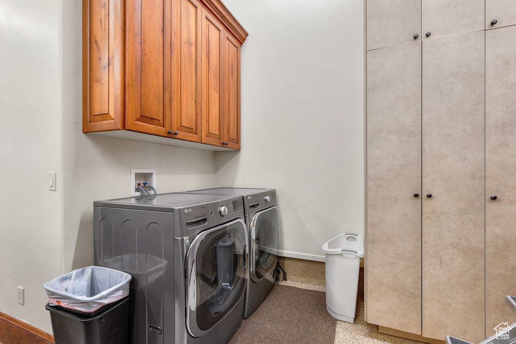 Laundry room featuring cabinets and separate washer and dryer