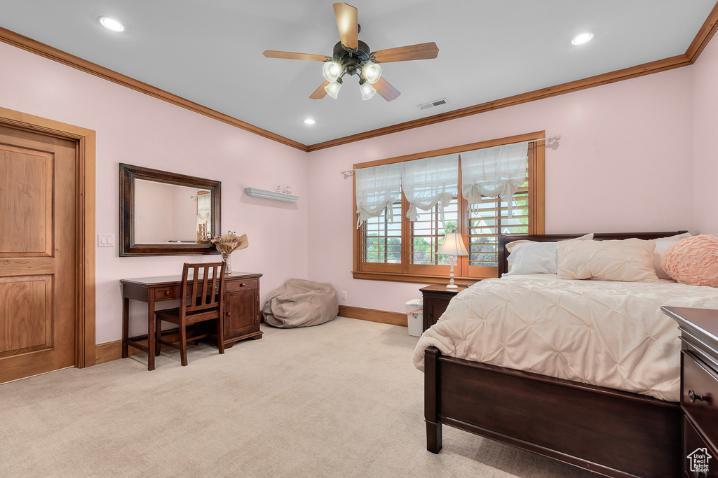 Carpeted bedroom with ceiling fan and crown molding