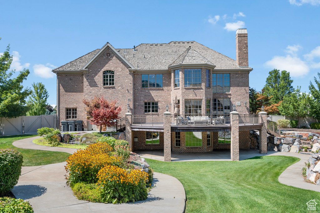 Rear view of property with a yard and a deck