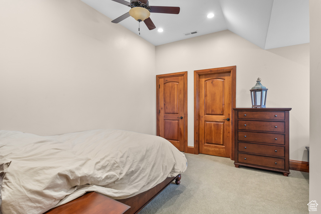 Carpeted bedroom with lofted ceiling and ceiling fan