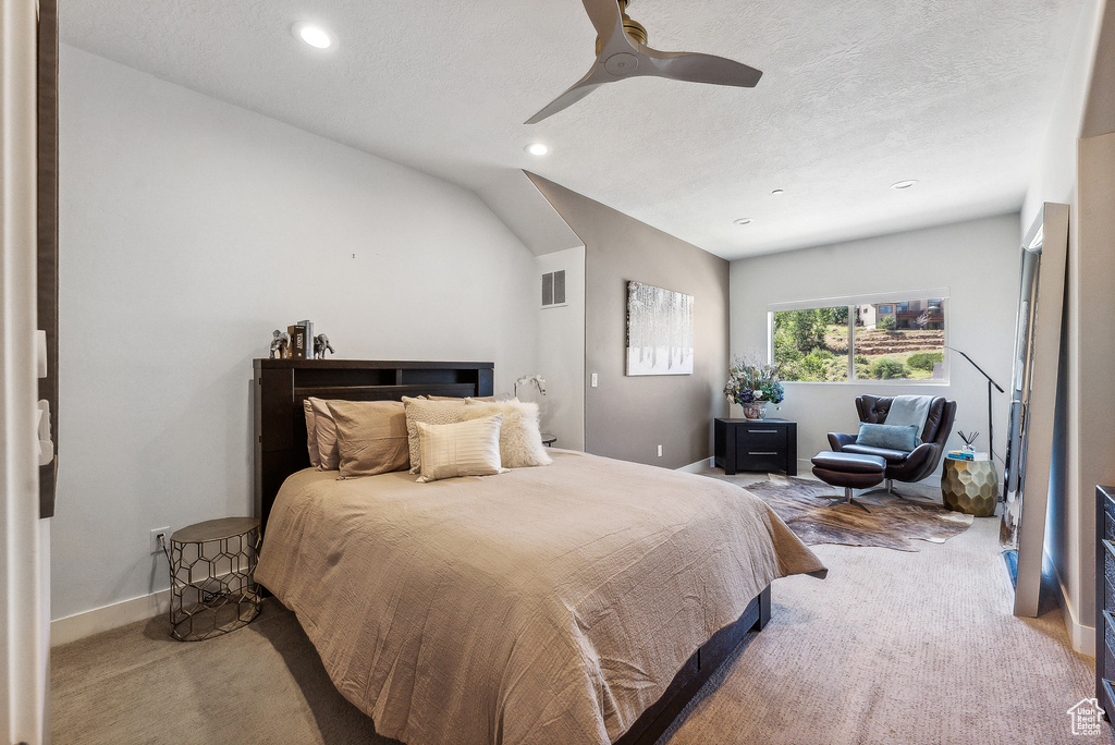 Carpeted bedroom featuring a textured ceiling and ceiling fan