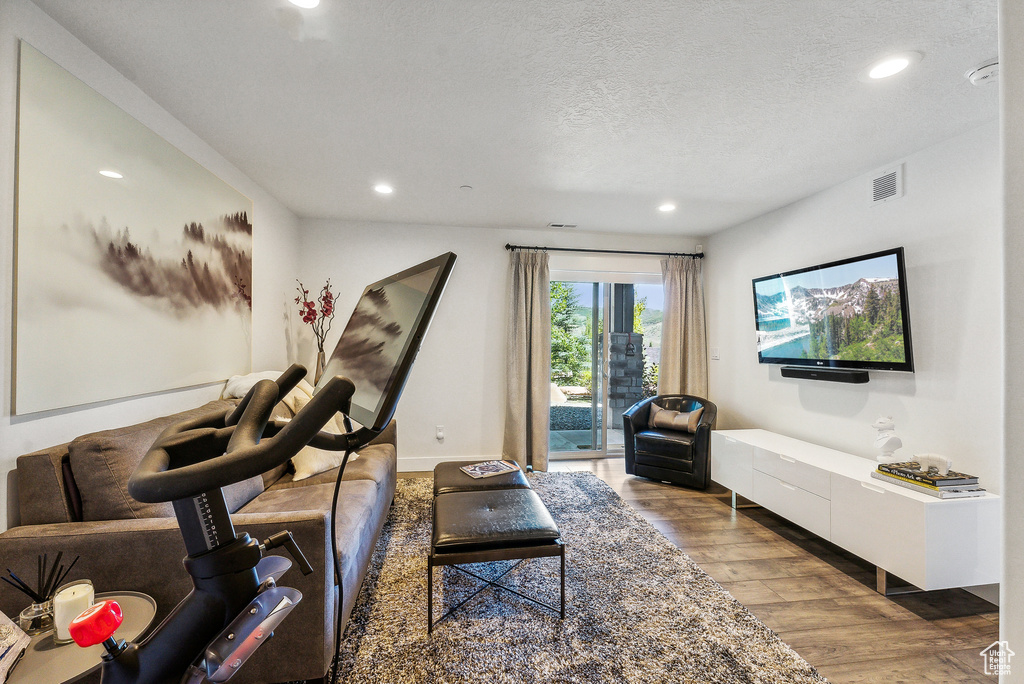 Workout room featuring a textured ceiling and wood-type flooring