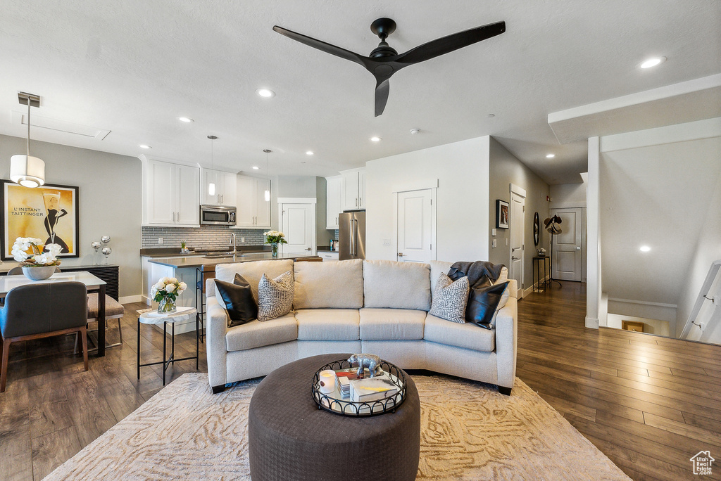 Living room featuring ceiling fan, sink, and wood-type flooring