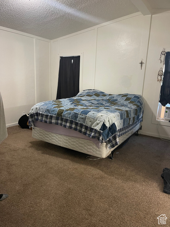 Bedroom featuring carpet flooring and a textured ceiling