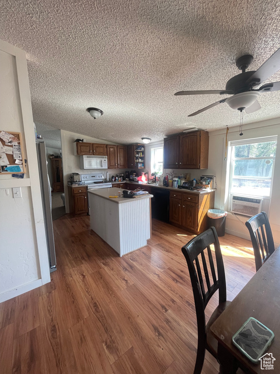 Kitchen with plenty of natural light, a center island, and hardwood / wood-style floors