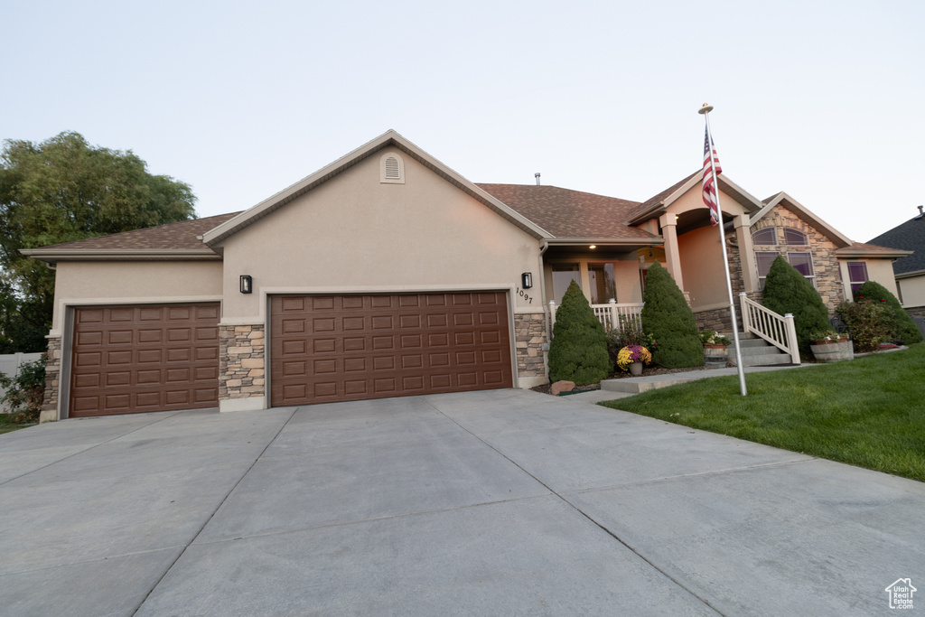 Ranch-style house with a garage and a front lawn