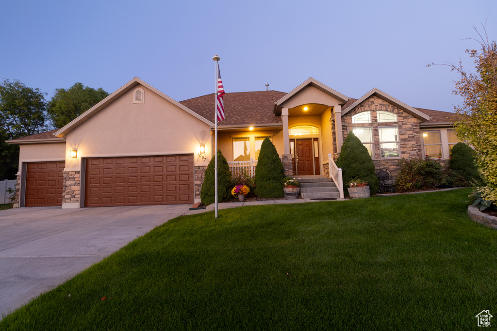 View of front facade featuring a yard and a garage