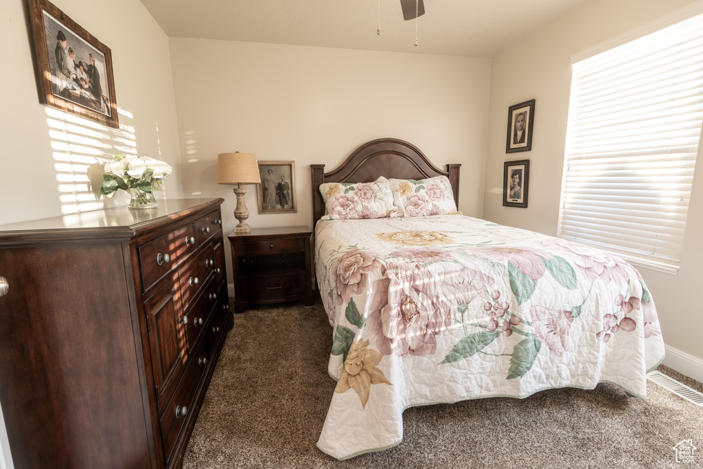 Bedroom with dark carpet and ceiling fan