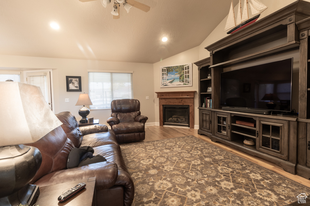 Living room featuring lofted ceiling, wood-type flooring, and ceiling fan