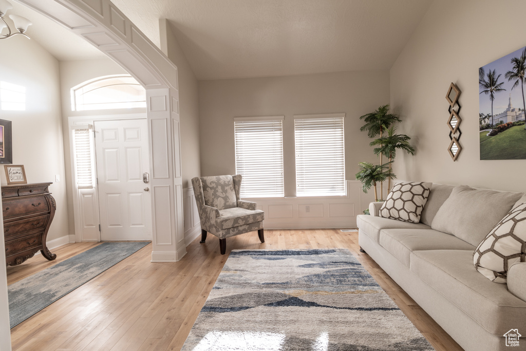 Living room featuring a healthy amount of sunlight, vaulted ceiling, and light wood-type flooring