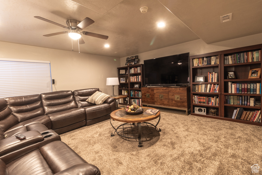 Living room with ceiling fan and light carpet