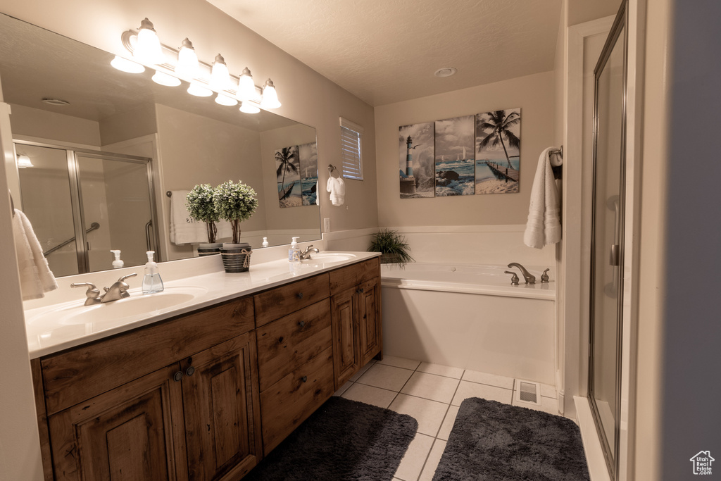 Bathroom featuring vanity, a textured ceiling, tile patterned floors, and shower with separate bathtub