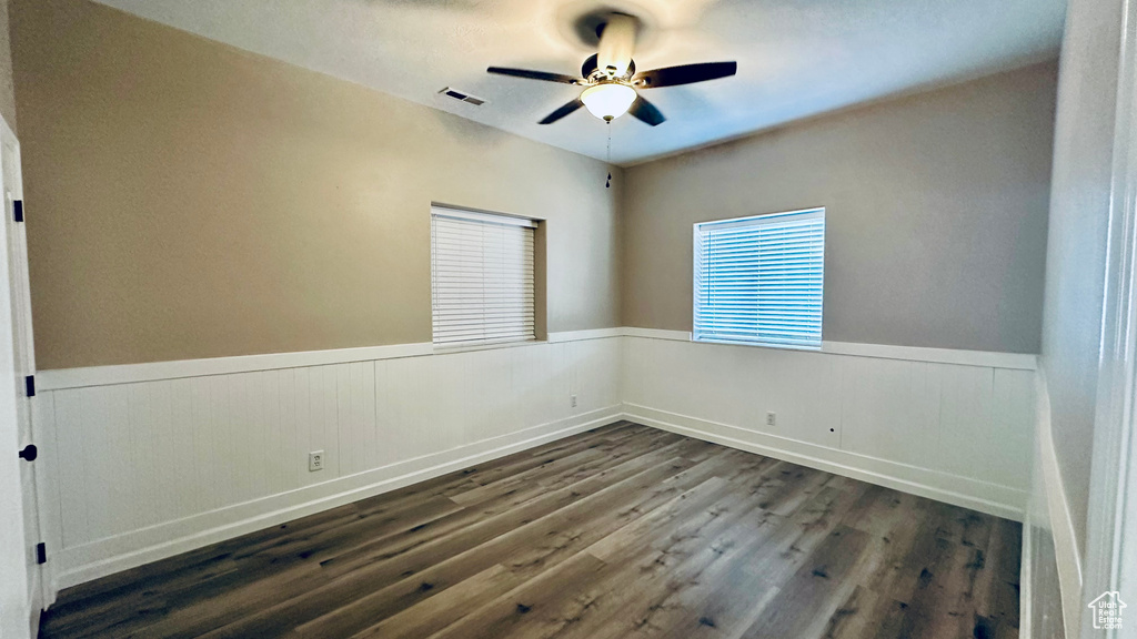 Unfurnished room with dark hardwood / wood-style flooring and ceiling fan