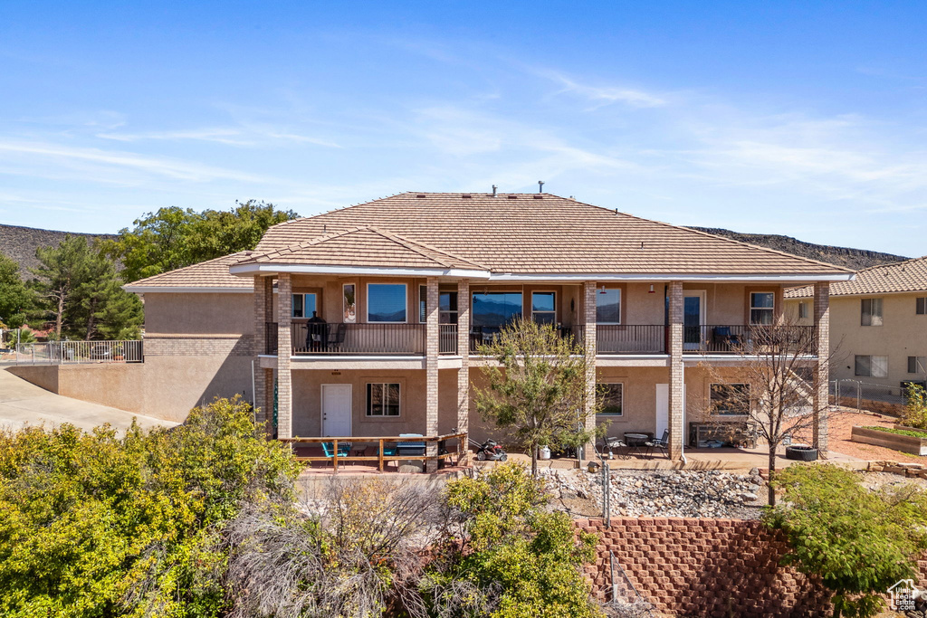 Back of property with a patio and a balcony