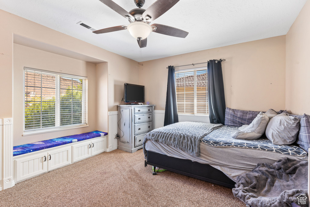 Bedroom with ceiling fan and light carpet