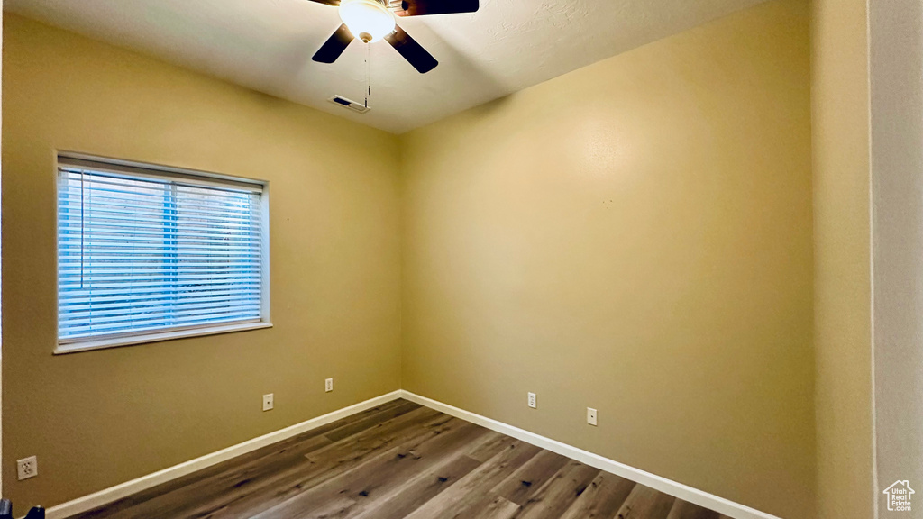 Spare room with wood-type flooring and ceiling fan