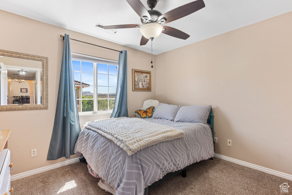 Carpeted bedroom featuring ceiling fan