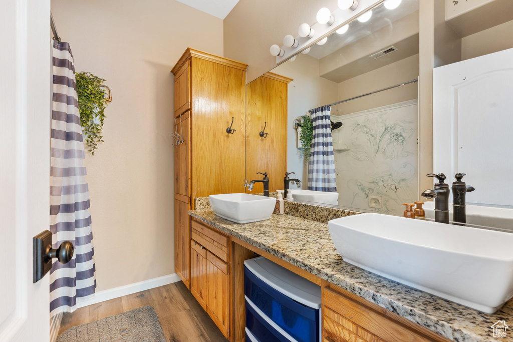 Bathroom with a shower with curtain, vanity, and hardwood / wood-style flooring