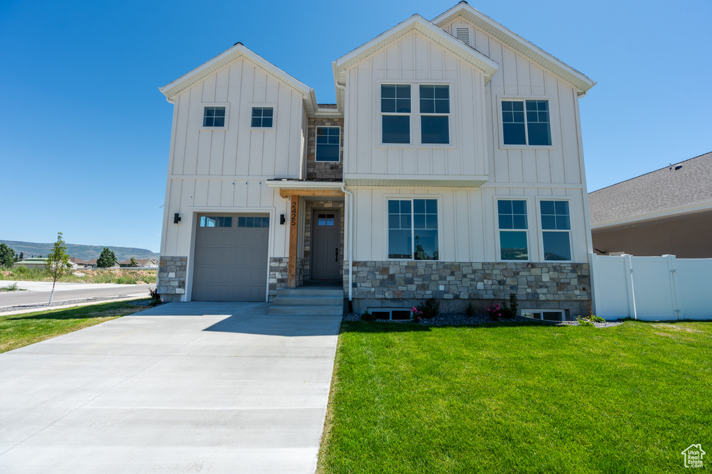 View of front of house with a garage and a front lawn