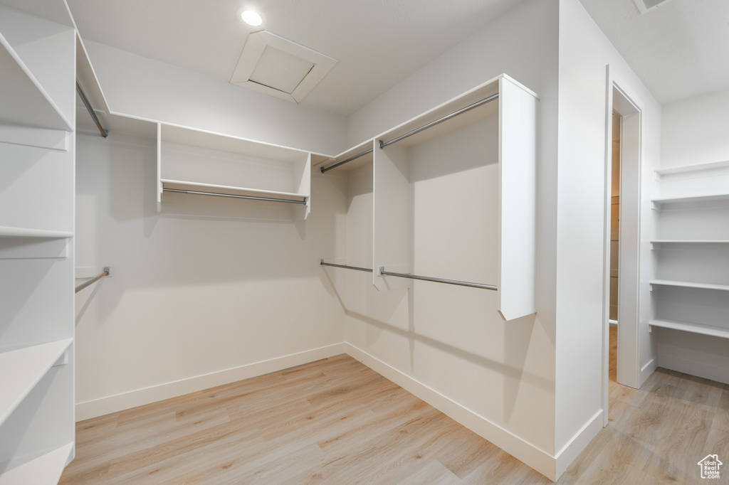 Spacious closet with light hardwood / wood-style flooring