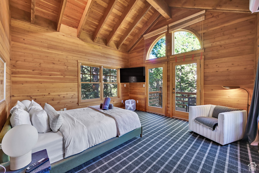 Carpeted bedroom with wooden walls, beam ceiling, access to outside, and wooden ceiling