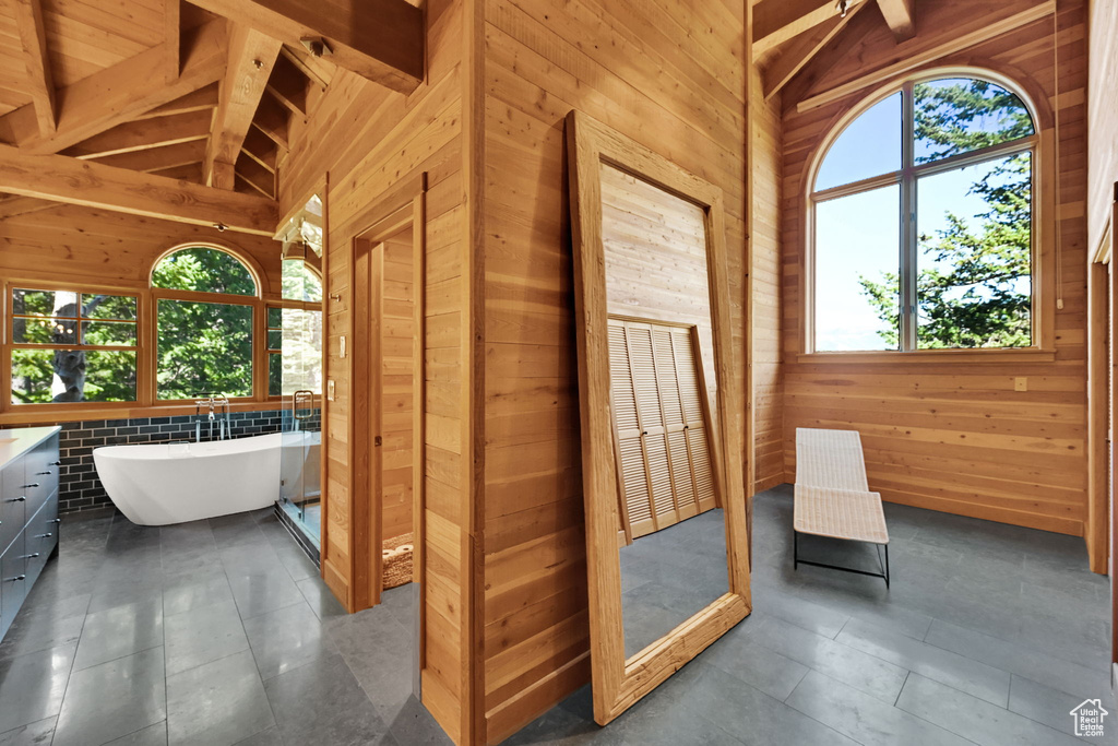 Interior space featuring wood walls, high vaulted ceiling, and beam ceiling