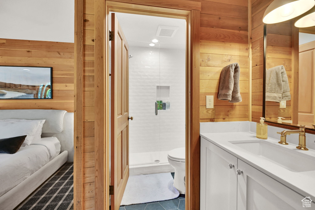 Bathroom featuring vanity, toilet, an enclosed shower, and wooden walls