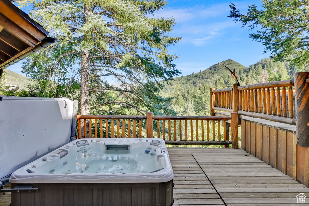 Wooden deck featuring a mountain view and a covered hot tub