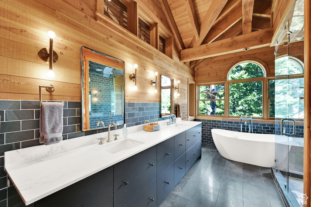 Bathroom featuring lofted ceiling with beams, wood ceiling, wood walls, tasteful backsplash, and vanity