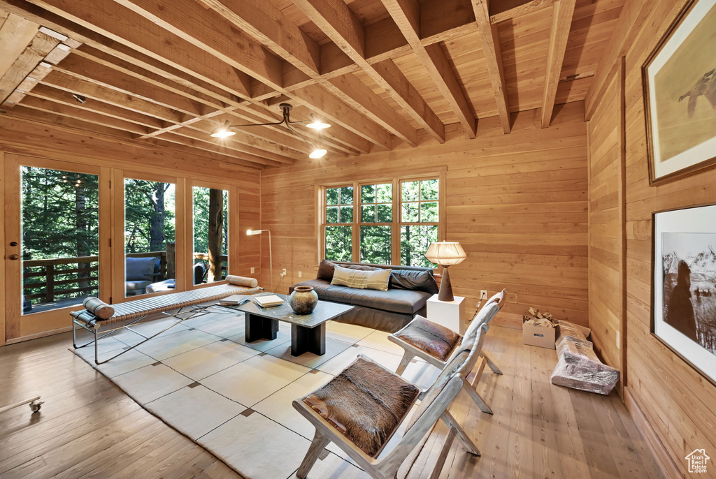 Living room with ceiling fan, plenty of natural light, and beam ceiling