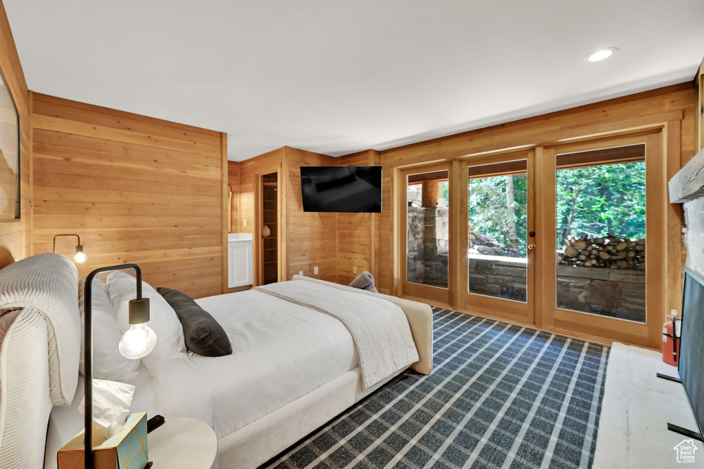 Bedroom featuring wood walls and access to outside