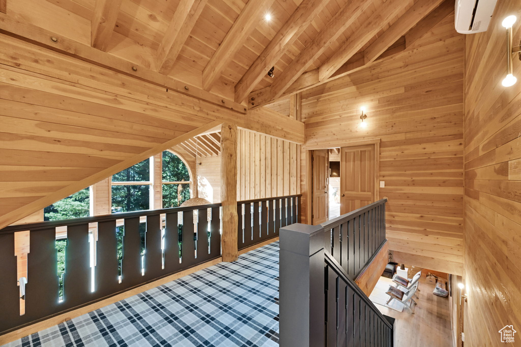 Interior space with wooden walls, wooden ceiling, and vaulted ceiling with beams