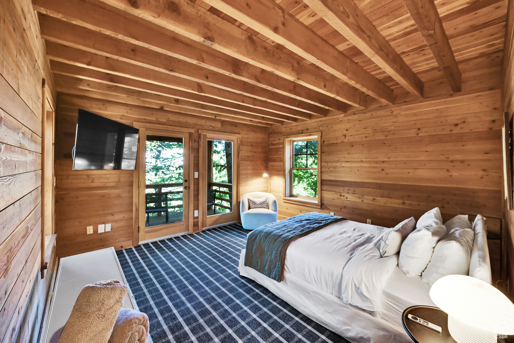 Bedroom with wood ceiling, access to exterior, wood walls, and beam ceiling