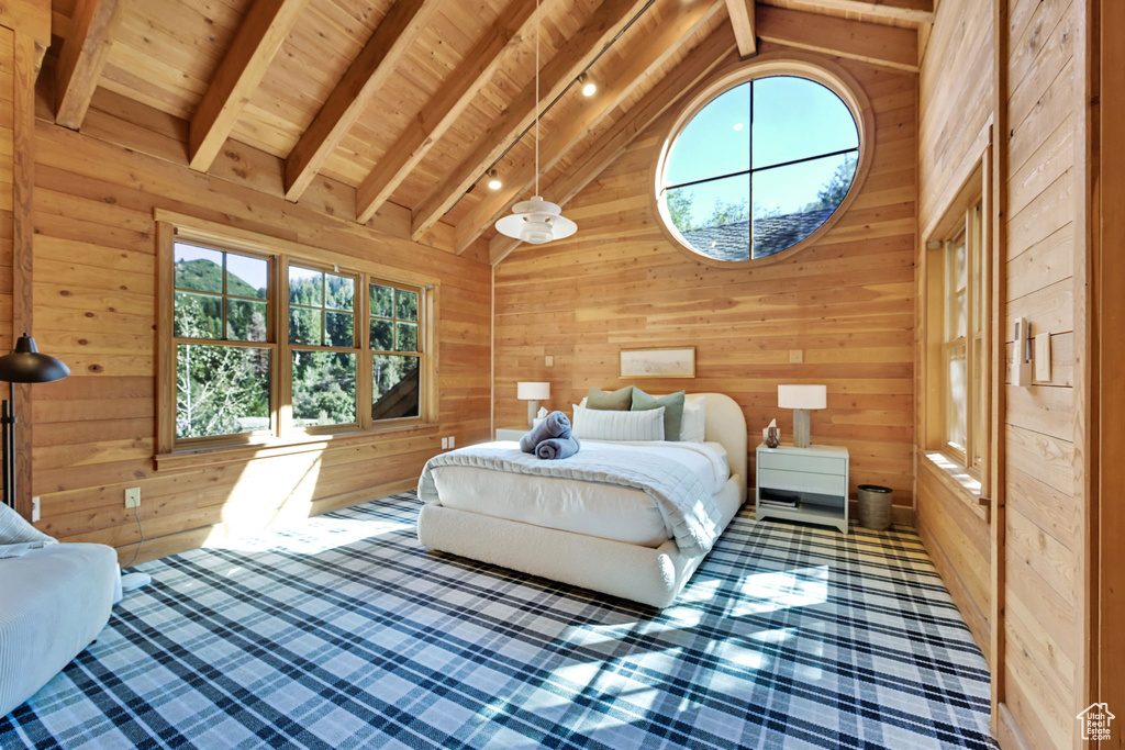 Bedroom featuring wood walls, wooden ceiling, and vaulted ceiling with beams