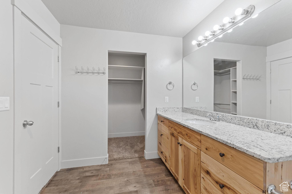 Bathroom featuring a textured ceiling, vanity, and hardwood / wood-style floors