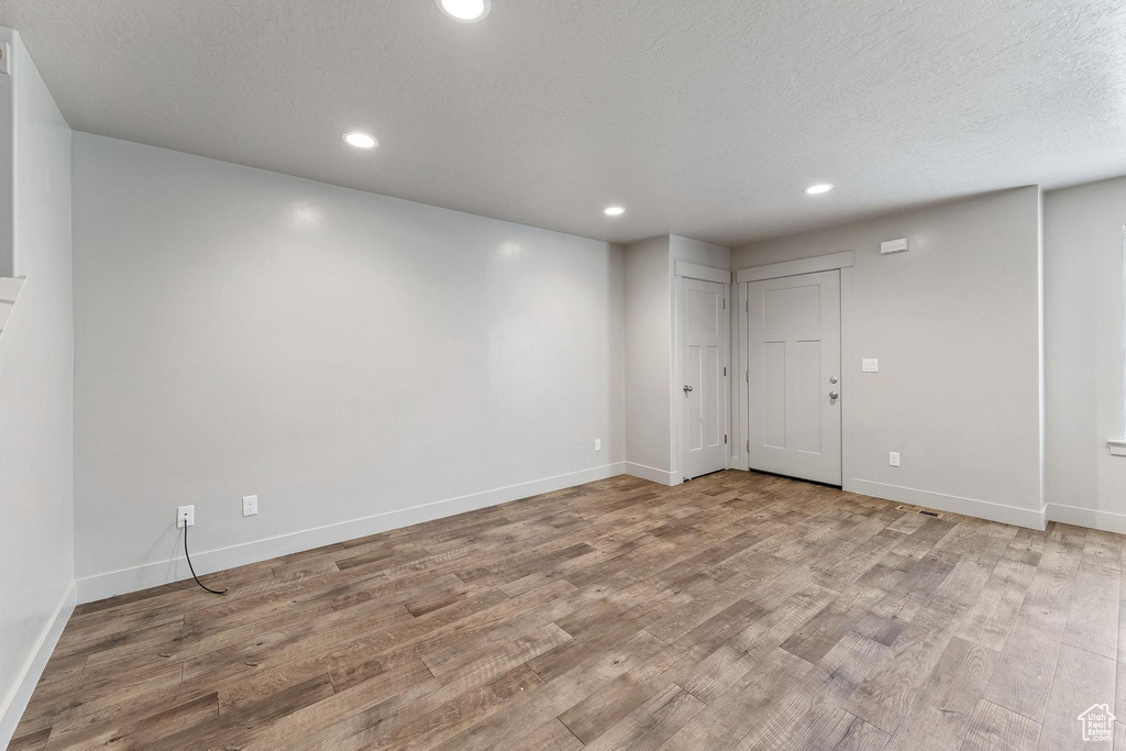 Unfurnished room featuring a textured ceiling and light hardwood / wood-style flooring