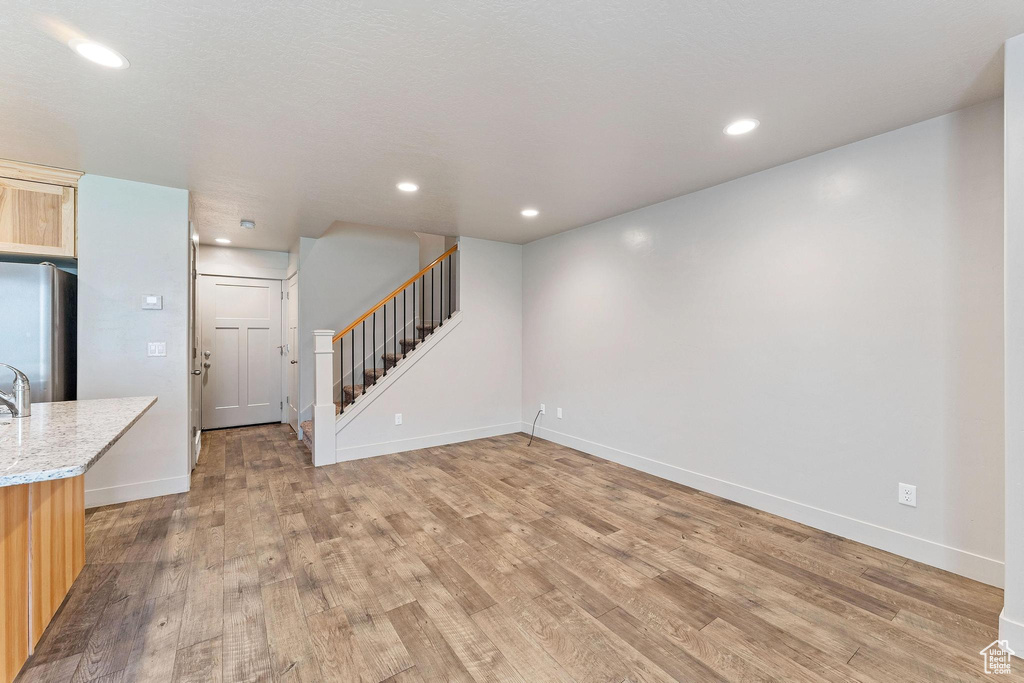 Unfurnished living room with hardwood / wood-style floors and sink