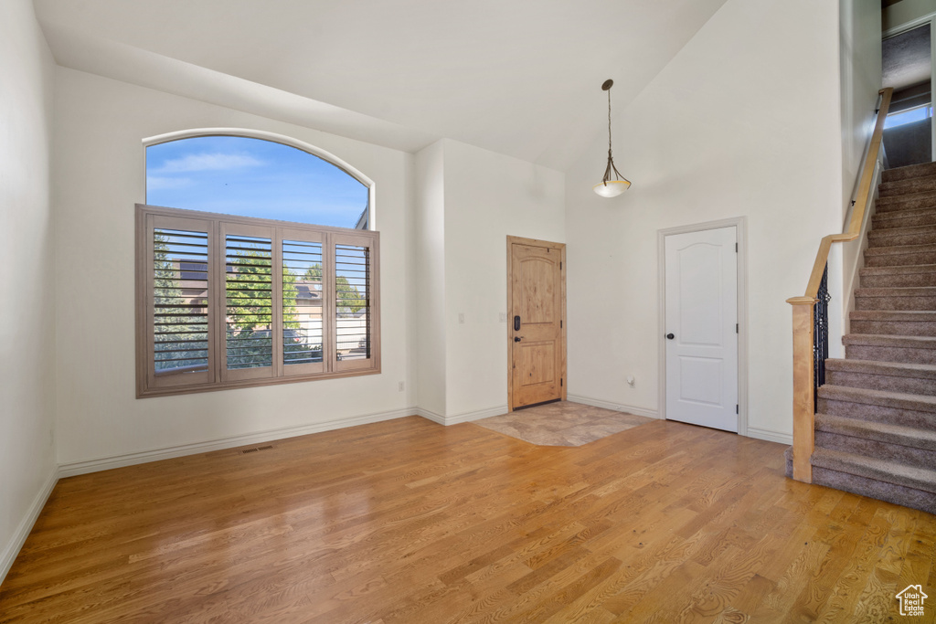 Entryway with a towering ceiling and light wood-type flooring