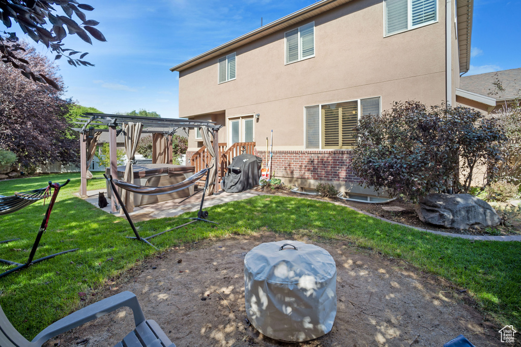 Back of house featuring a lawn, a patio, and a pergola