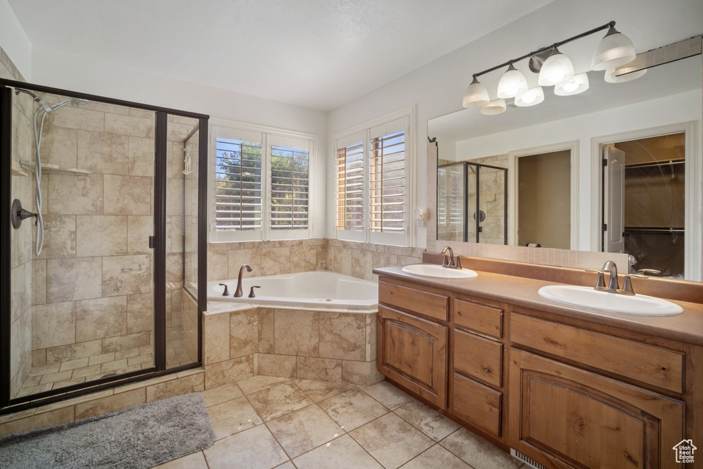 Bathroom featuring vanity, tile patterned floors, and plus walk in shower