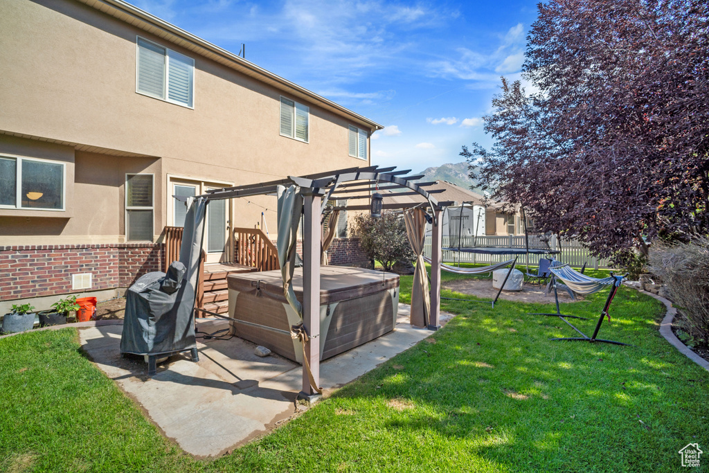 View of yard featuring a patio, a hot tub, and a pergola