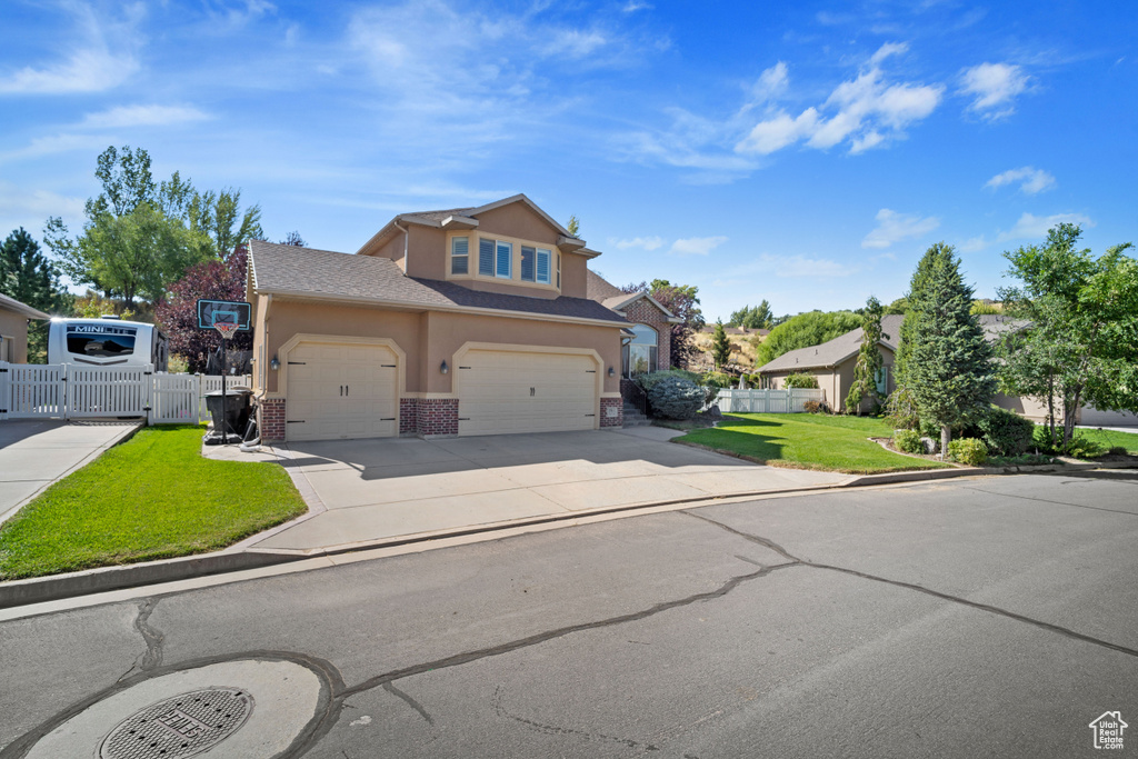 View of front of house featuring a front yard and a garage