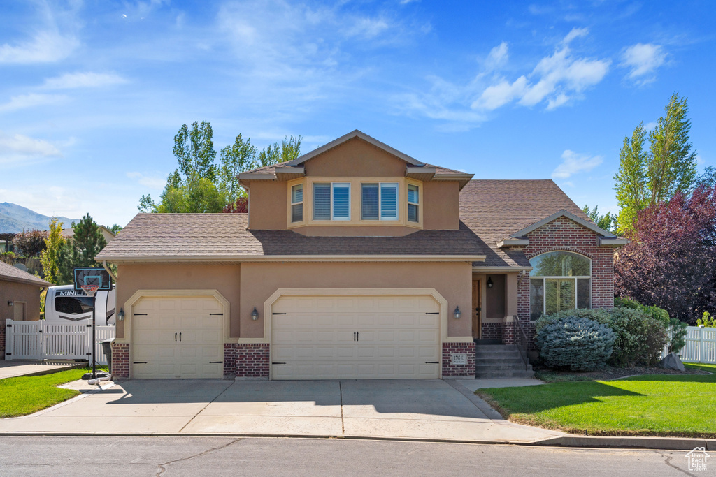 View of front of house with a garage and a front lawn