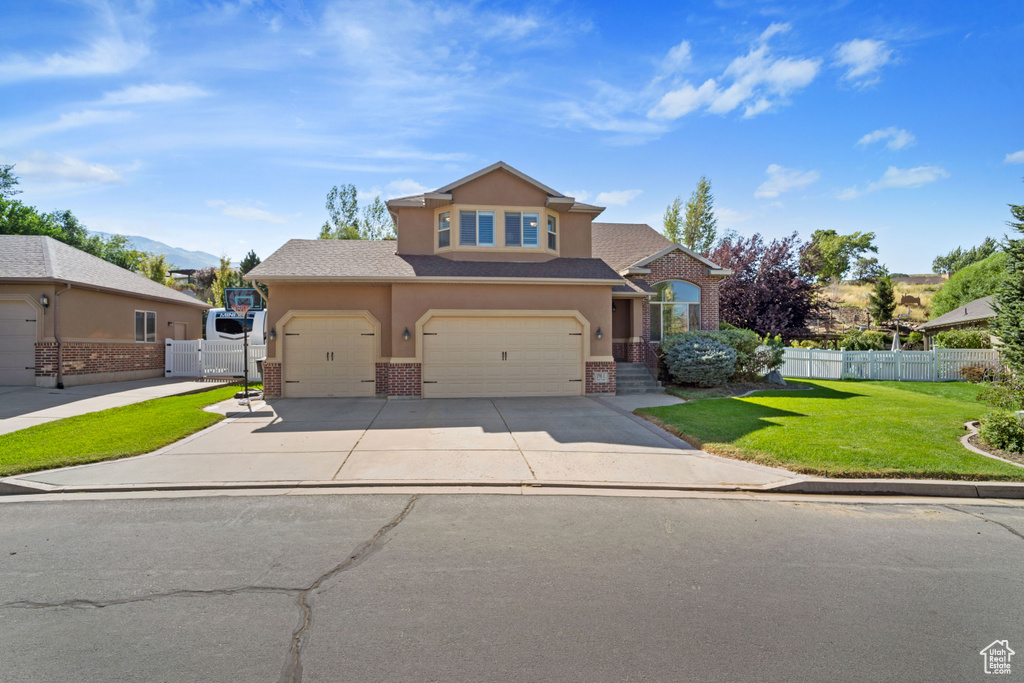 View of front of home featuring a front yard and a garage