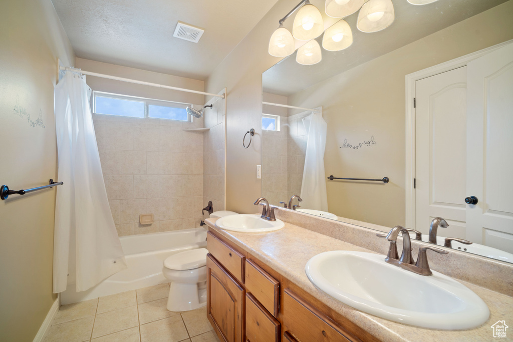 Full bathroom with vanity, toilet, shower / tub combo, and tile patterned floors