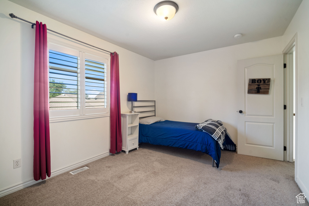 Bedroom featuring light colored carpet