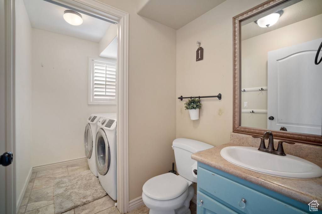 Bathroom featuring vanity, toilet, and washer and clothes dryer